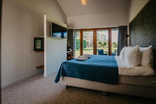 1 dormitorio con 1 cama con edredón azul en Motel-Restaurant-Grand Cafe de Caisson en Kapelle
