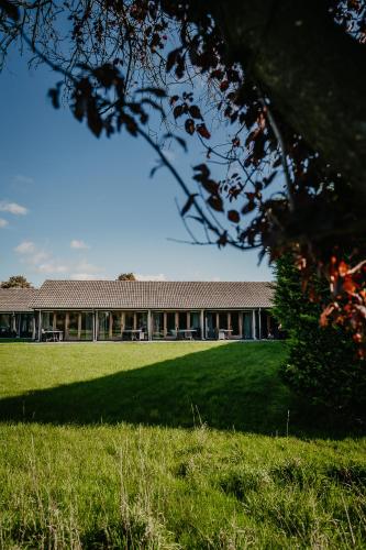 a large building with a green field in front of it at Motel-Restaurant-Grand Cafe de Caisson in Kapelle