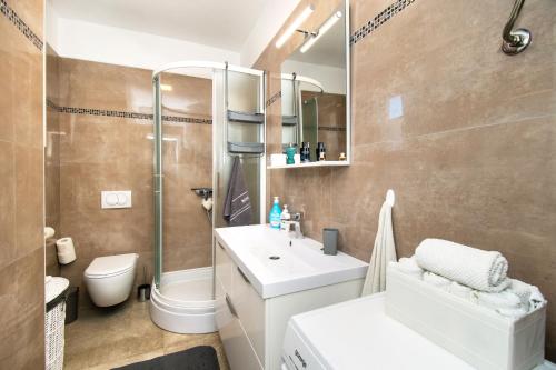 La salle de bains est pourvue d'un lavabo, d'une douche et de toilettes. dans l'établissement Apartman Benmi, à Vodice