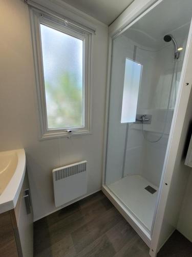 une salle de bain avec une douche et un lavabo et une fenêtre dans l'établissement MOBIL HOME 68 JARDINS ATLANTIQUE, à Saint-Jean-de-Monts