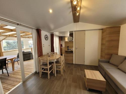 a living room and kitchen with a couch and a table at MOBIL HOME 68 JARDINS ATLANTIQUE in Saint-Jean-de-Monts