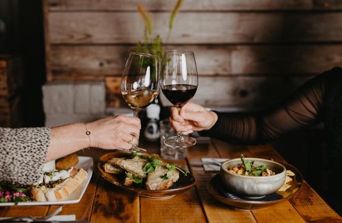 two people sitting at a table with glasses of wine at Motel-Restaurant-Grand Cafe de Caisson in Kapelle