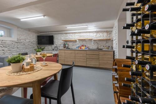 a room with a table and a wall of wine bottles at Wellness Apartmány Vila Republika in Velké Losiny