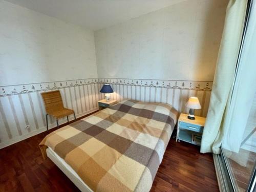 une chambre avec un lit, une chaise et une fenêtre dans l'établissement Quiberon - Appartement 3 pièces 50m² avec Parking et Animaux admis - FR-1-478-92, à Quiberon