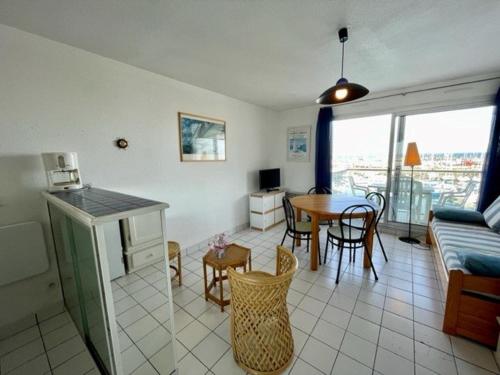 une cuisine et un salon avec une table et des chaises dans l'établissement Quiberon - Appartement 2 pièces - Terrasse - Parking - Animaux admis - FR-1-478-106, à Quiberon
