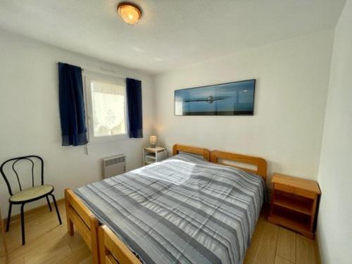 une chambre avec un lit et une chaise dedans dans l'établissement Quiberon - Appartement 2 pièces - Terrasse - Parking - Animaux admis - FR-1-478-106, à Quiberon