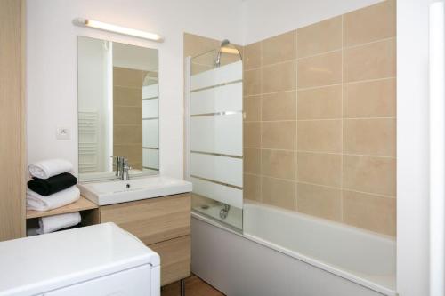een badkamer met een bad, een wastafel en een toilet bij appartement vacances en copropriété avec parking in Saint-Malo