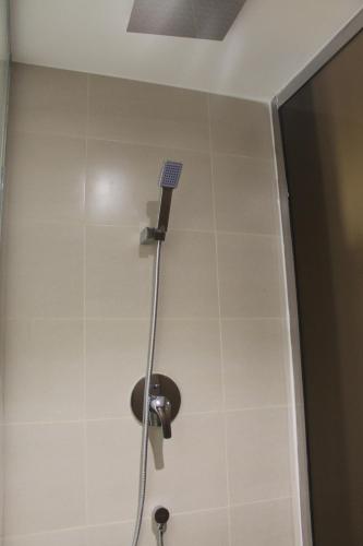 a shower with a shower head in a bathroom at High Village Hotel in Al Namas