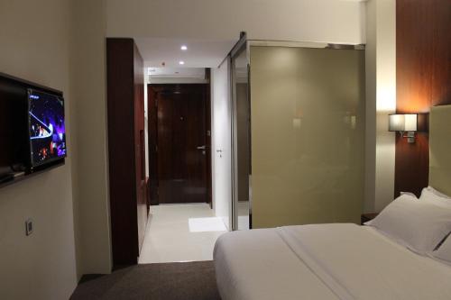 a hotel room with a bed and a sliding glass door at High Village Hotel in Al Namas