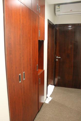 a corridor with wooden cabinets and a door in a room at High Village Hotel in Al Namas