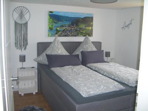 a small bedroom with a bed with white and blue pillows at Ferienwohnung RheinSpaziert in Dellhofen