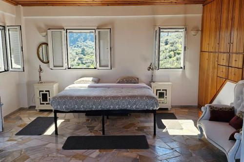 1 dormitorio con 1 cama, 2 ventanas y sofá en Peloponnese Hideout - White house with the sea view en Akrata