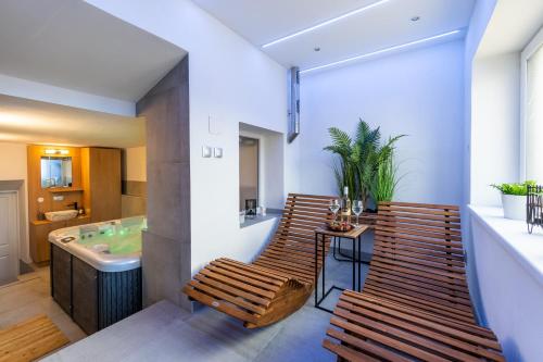 uma casa de banho com 2 cadeiras e uma banheira em Wellness Apartmány Vila Republika em Velké Losiny