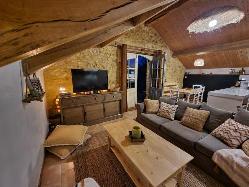 sala de estar con sofá y mesa en La Ferme de Philomène - Gîte en Périgord Noir en Sainte-Foy-de-Belvès