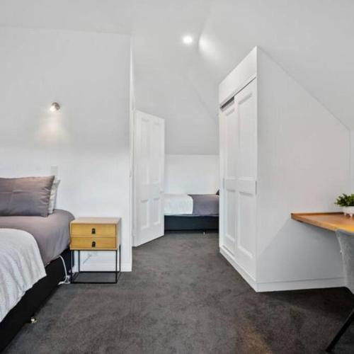 a bedroom with a bed and a night stand and a table at LUCAS Street in Kingston