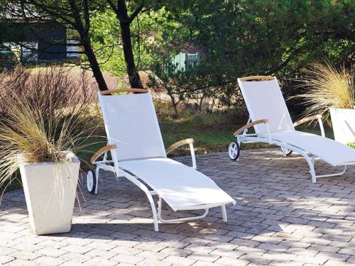 2 chaises blanches assises sur un patio en briques dans l'établissement 6 person holiday home in R m, à Vesterhede