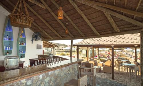 un restaurante con un bar con mesas y sillas en Peaceful Private Villa at Five Star Beach Resort, en Ras al Khaimah