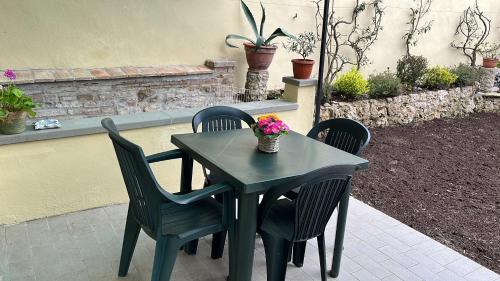 een tafel en stoelen met bloemen op een patio bij CASA DI SILVIA_MONOLOCALE in Città di Castello