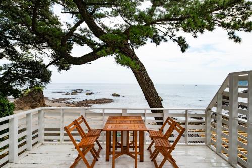 a table and chairs on a deck with a view of the ocean at BLUE MOON in Kawazu