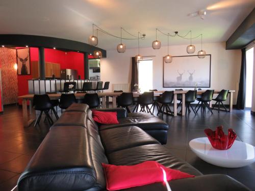 a living room with a couch and tables and chairs at Oxygen House, Holiday and Team building in Ovifat