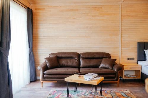 sala de estar con sofá marrón y mesa en Serenity Bungalows, en Cıralı
