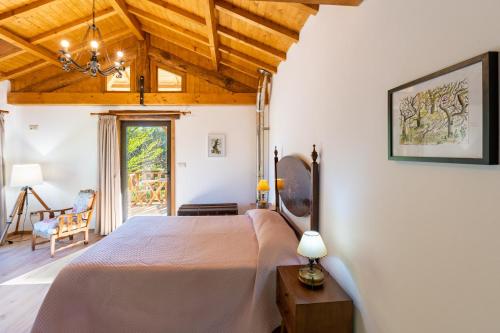 a bedroom with a large bed with a wooden ceiling at Casa da Eira "Lavoura da Bouça - Fruta Bio" in Celorico de Basto