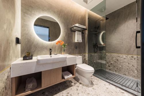 a bathroom with a sink and a toilet and a mirror at Livetour Hotel Shenzhou Road Metro Guangzhou in Guangzhou