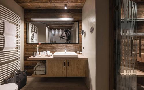 ein Bad mit einem Waschbecken und einem Spiegel in der Unterkunft Alpin Boutique Villa Gabriela - Adults Only in Kastelruth