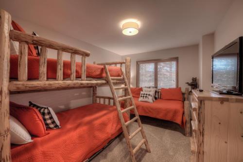 a bedroom with two bunk beds and a television at Los Pinos Columbine Condo Nice Updates Stroll to Lift in Breckenridge