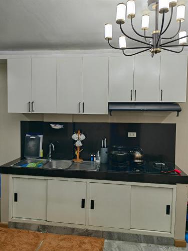 a kitchen with white cabinets and a sink at You Can afford To Dwell Well in Manila