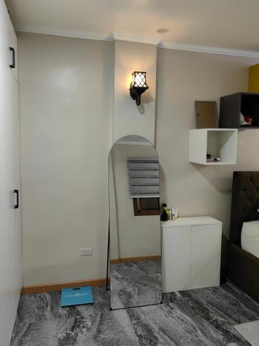 een kamer met een bed en een spiegel aan de muur bij You Can afford To Dwell Well in Manilla