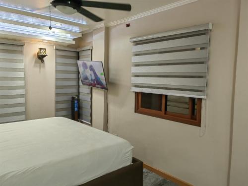 een slaapkamer met een bed en een raam bij You Can afford To Dwell Well in Manilla