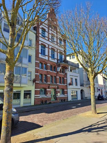 een groot bakstenen gebouw in een stadsstraat met bomen bij Urige Ferienwohnung im Hafen Stralsunds in Stralsund