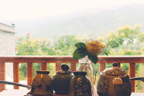 three vases on a table with a view of a mountain at Wild House in Deqing