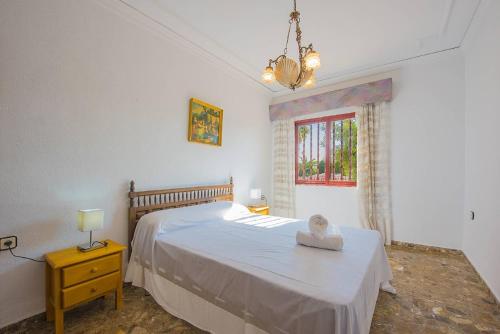 a bedroom with a white bed and a window at Villa Lina - PlusHolidays in Calpe