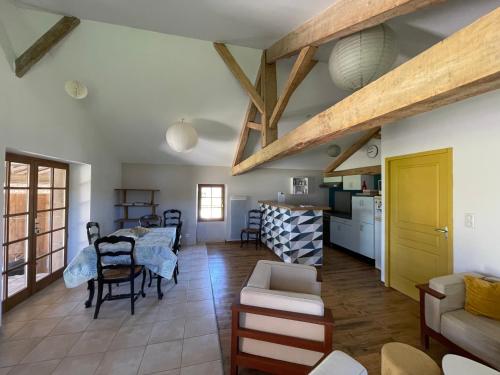 une cuisine et un salon avec une table et des chaises dans l'établissement Gîte à la Ferme de Verdurette Cordes-sur-Ciel, à Cordes-sur-Ciel