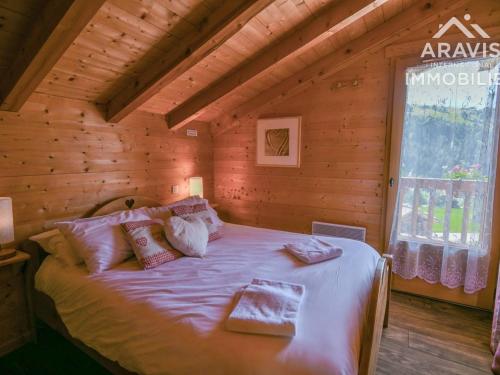 ein Schlafzimmer mit einem Bett in einem Blockhaus in der Unterkunft Chalet Le Grand-Bornand, 5 pièces, 8 personnes - FR-1-391-45 in Le Grand-Bornand