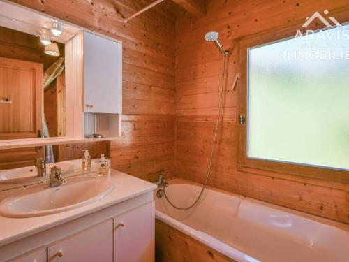 ein Bad mit einem Waschbecken, einer Badewanne und einem Fenster in der Unterkunft Chalet Le Grand-Bornand, 5 pièces, 8 personnes - FR-1-391-45 in Le Grand-Bornand