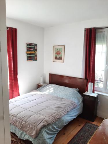 une chambre avec un lit avec des rideaux rouges et une fenêtre dans l'établissement Chambre Eugénie, à Saint-Cloud