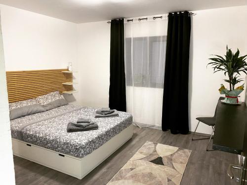a bedroom with a bed and a window with black curtains at Casa.Puf in Techirghiol
