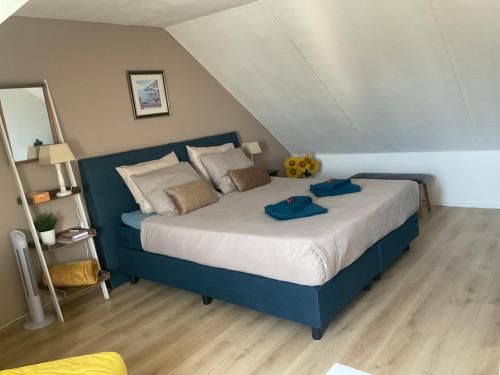 1 dormitorio con 1 cama azul y 2 toallas azules en B&B Holiday-44, en Enkhuizen