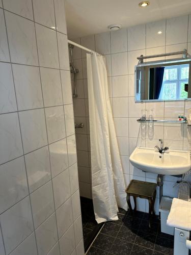 een badkamer met een wastafel en een douche bij Hotel Huys ter Schelde in Koudekerke