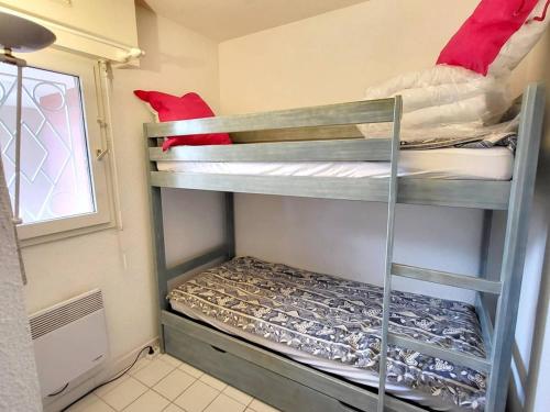 Cette petite chambre dispose de 2 lits superposés et d'une fenêtre. dans l'établissement T3 avec Piscine - Tennis - Parking - À 200m des plages/commerces - FR-1-316-294, à Six-Fours-les-Plages