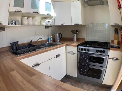 a kitchen with a stove and a sink at Whitwell and Reepham Station - GEORGIE in Reepham