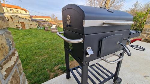 a grill sitting on a stand next to a yard at HIŠA KAPIŠ with HOT TUBE in Koper