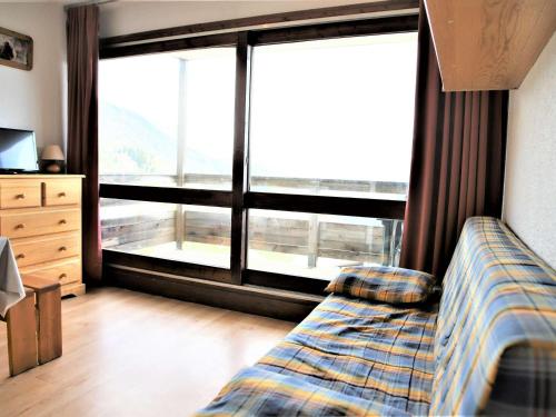 sypialnia z łóżkiem i dużym oknem w obiekcie Studio cabine fermée, 4 couchages, balcon ensoleillé, au pied des pistes - Auris en Oisans - FR-1-297-306 w mieście Auris