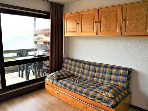 - un canapé dans une pièce avec fenêtre dans l'établissement Studio cabine fermée, 4 couchages, balcon ensoleillé, au pied des pistes - Auris en Oisans - FR-1-297-306, à Auris