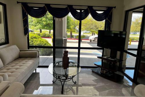 a living room with a couch and a tv at Super 8 by Wyndham Slidell in Slidell
