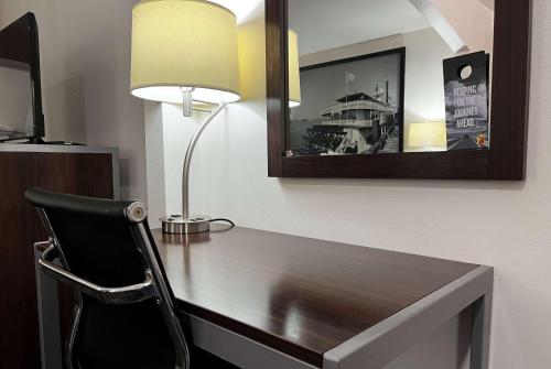 een bureau met een lamp en een stoel in een kamer bij Super 8 by Wyndham Slidell in Slidell