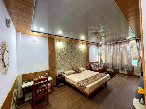Plaza Hotel في Pithorāgarh: غرفة نوم بسرير وطاولة ومكتب